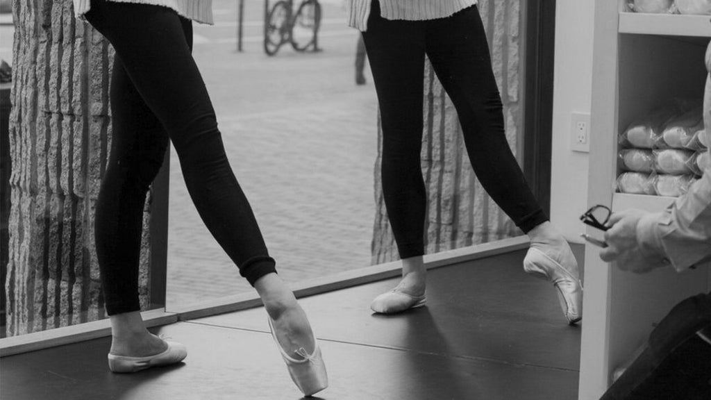 Two dancers in a studio practicing ballet 