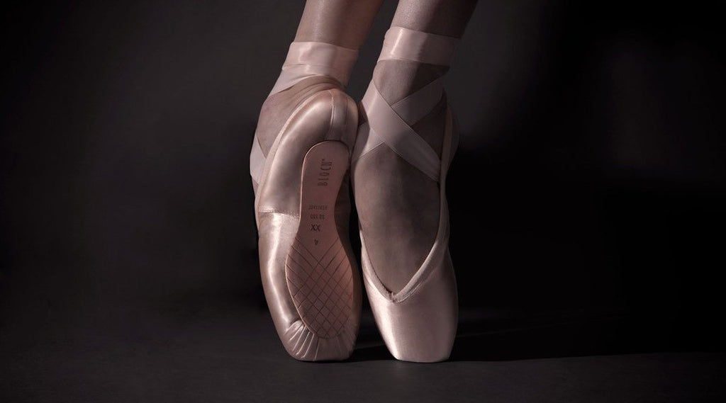Dancers feet en pointe wearing pointe shoes